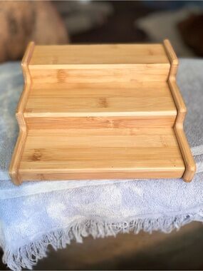 Bamboo 3 tiered expandable spice rack with natural wood grain.